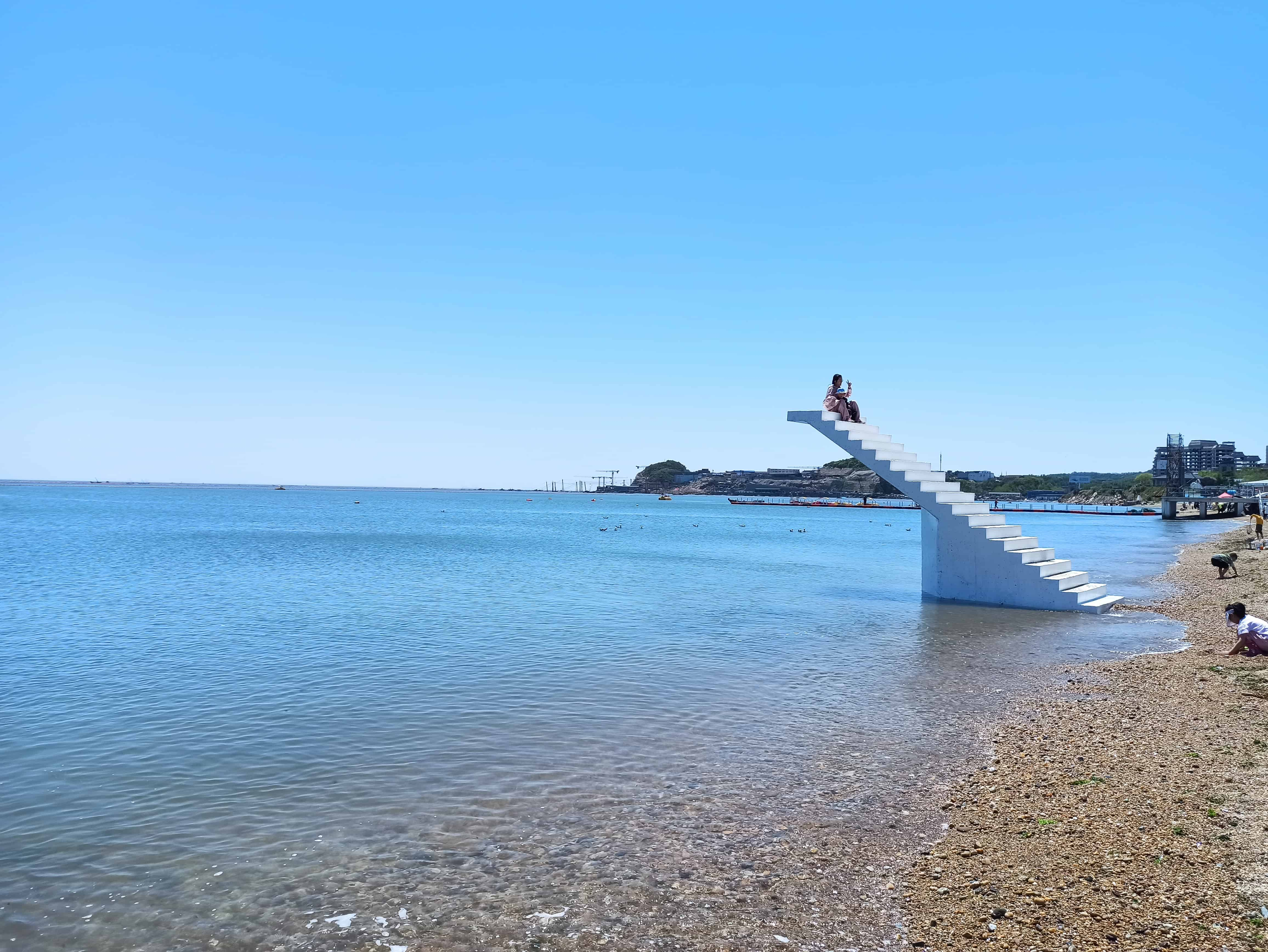 有遊客在海邊拍照